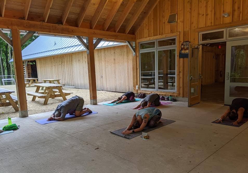 a group of adults doing yoga outside at the Riveredge Sugarbush House