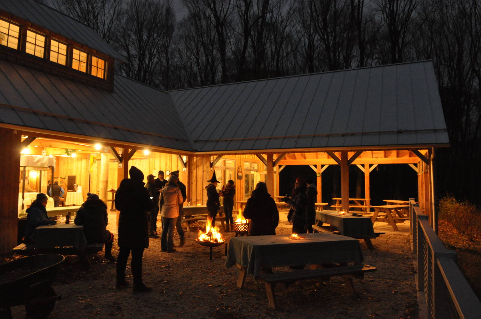 nighttime view of the sugarbush house lit up with people attending an event