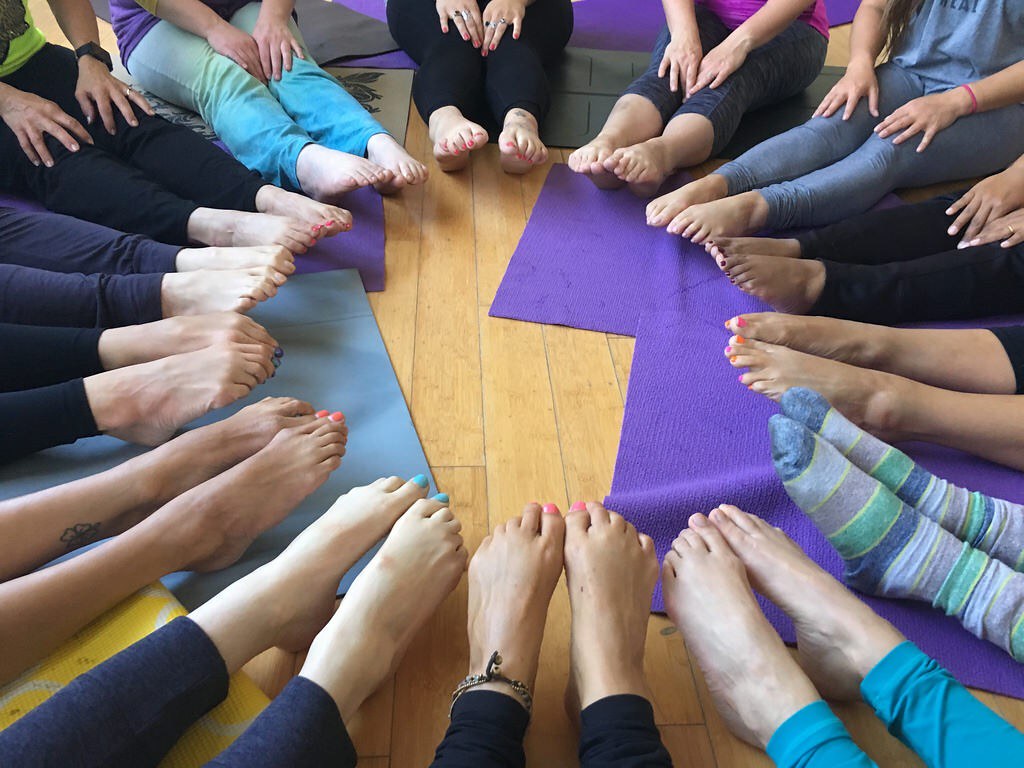kids legs in a circle together on the floor with yoga mats