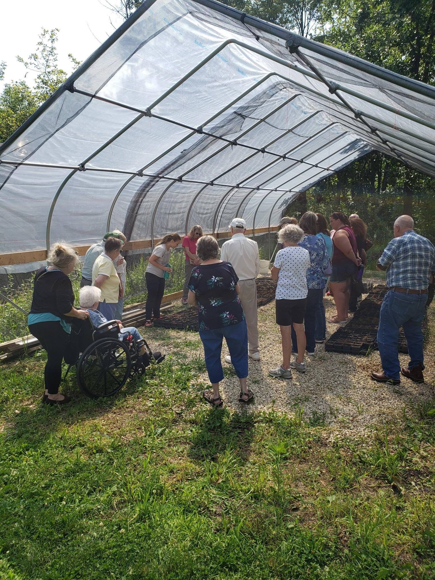 group of senior adults looking at seeds in a Riverede greenhouse