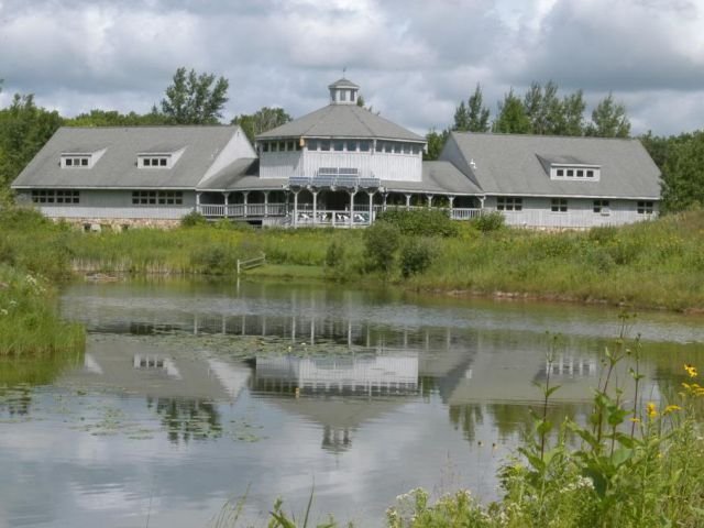 Riveredge's main building from a distance with Farm pond in front