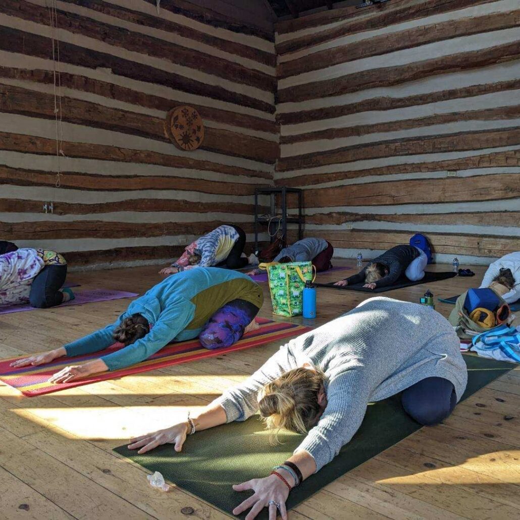 7 people doing yoga on mats in the Riveredge barn