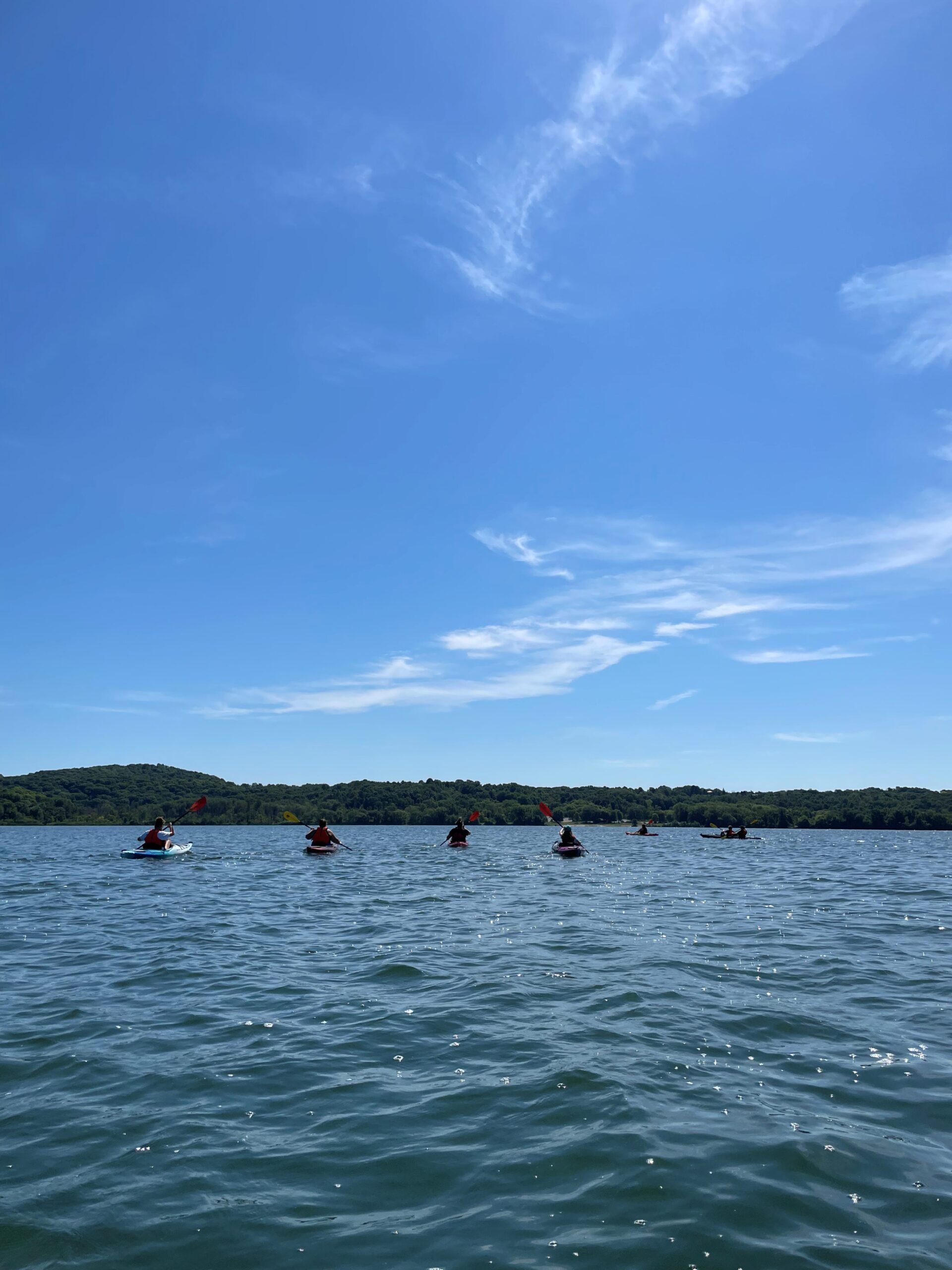 scenic view of kayaks on a lake in the distance with a clear blue sky above